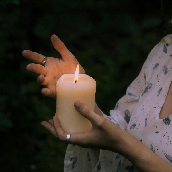 Person meditating peacefully in a calm, dark environment with soft light.